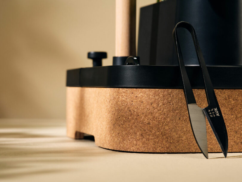 A pair of scissors next to a cork board.