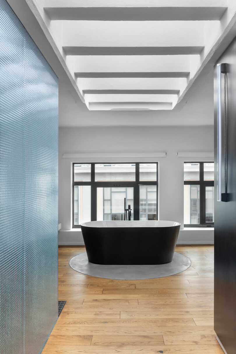 looking down hallway into bathroom with floating tub