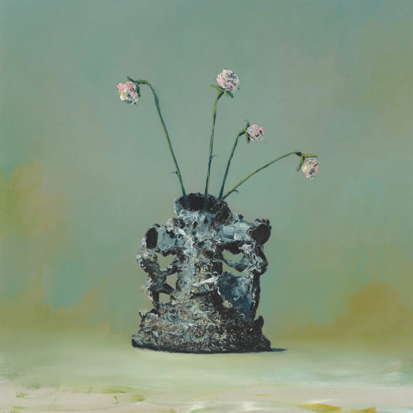 A vase with an irregular, textured surface by Laura Casañas Maya holds four pink flowers with long, thin stems, set against a muted green background.