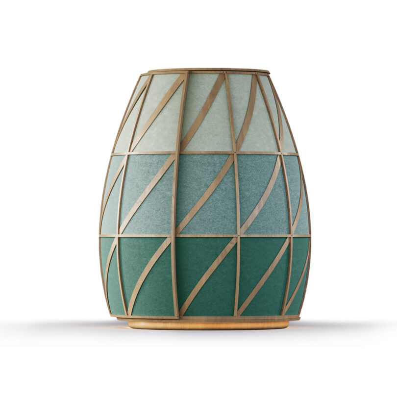 A decorative structure with a geometric pattern in shades of green and blue, outlined by thin gold lines, standing on a round wooden base.
