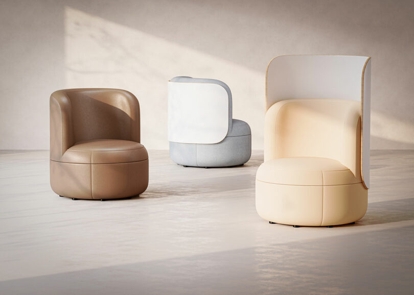 Three modern, curved armchairs in beige, brown, and white are displayed on a light floor against a plain, softly lit background.