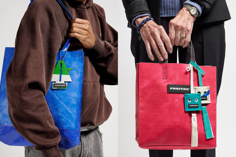 Two people are holding colorful FREITAG tote bags, one blue and one red, each decorated with unique, playful keychains and accessories.