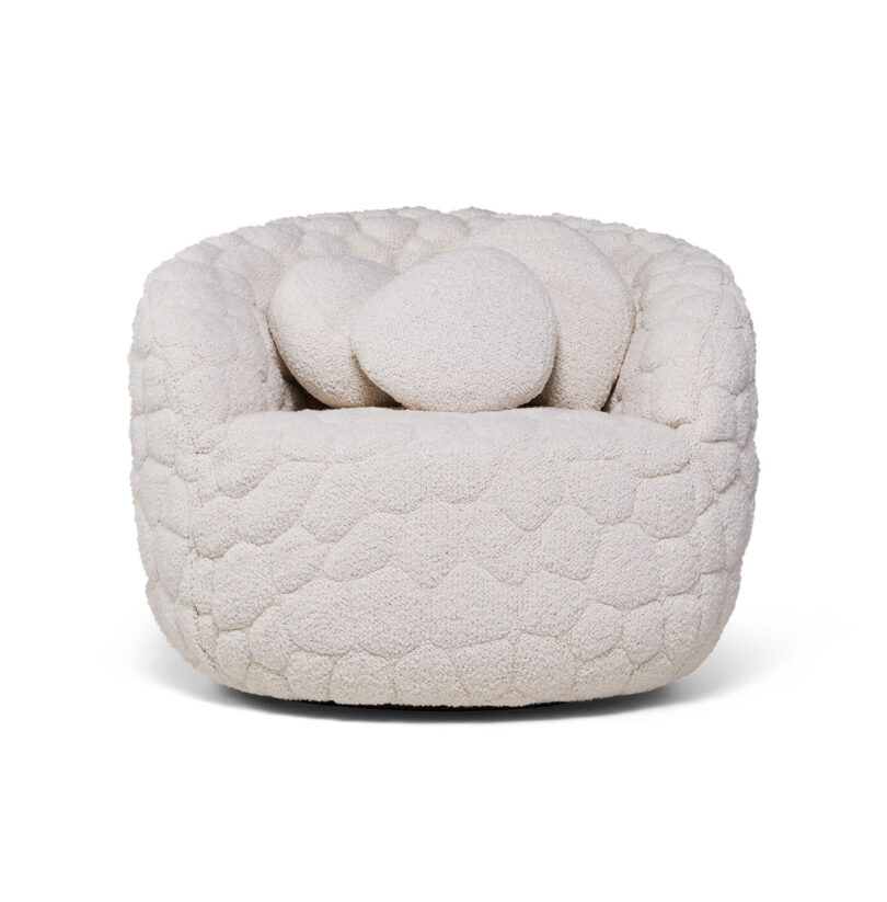 A cream-colored, textured armchair with a rounded shape and two matching circular cushions, viewed from the front.