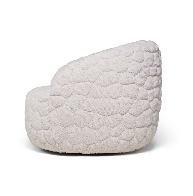 A modern, white, textured lounge chair with a rounded, pebble-like surface design, shown in side view against a plain background.